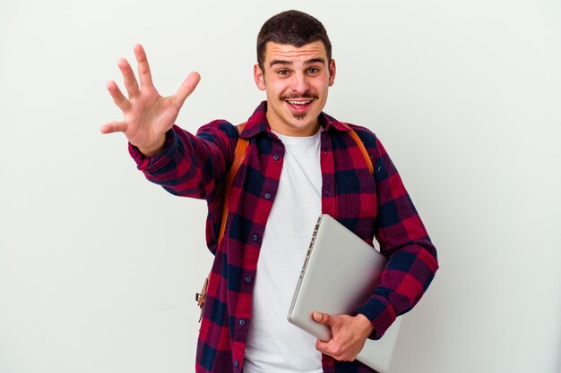 Young caucasian student man holding a laptop on white feels confident giving a hug