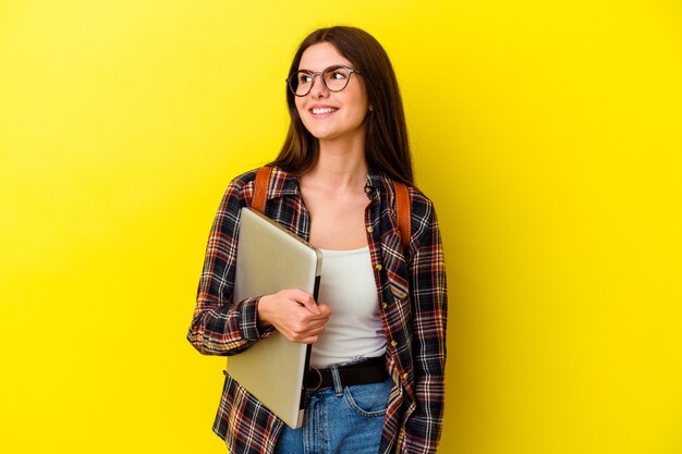 Foto giovane donna caucasica dell'allievo che tiene un computer portatile isolato