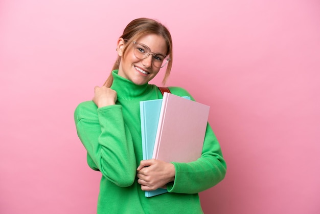 Young caucasian student woman isolated on pink background laughing