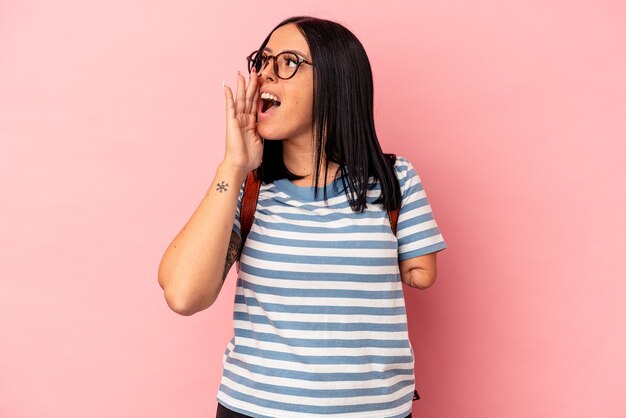 Young caucasian student woman with one arm isolated on pink background shouting and holding palm near opened mouth.