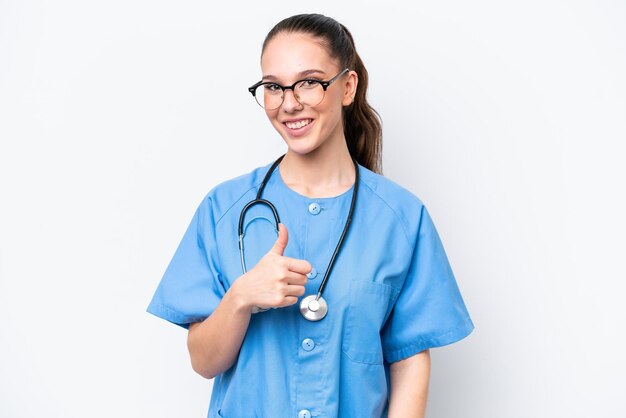 young caucasian surgeon doctor woman isolated on white background giving a thumbs up gesture