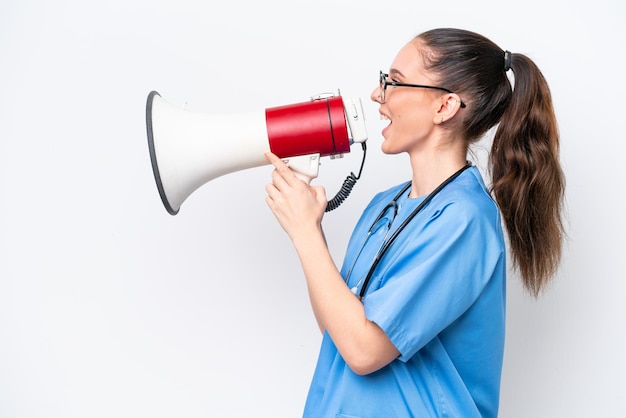 Photo young caucasian surgeon doctor woman isolated on white background shouting through a megaphone