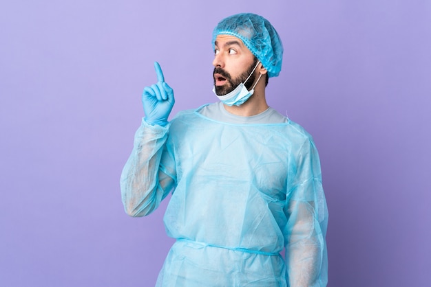 Young caucasian surgeon man over isolated purple wall