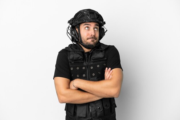 Young caucasian swat isolated on white background making doubts gesture while lifting the shoulders