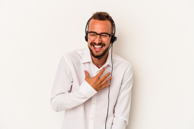 Photo young caucasian telemarketer man with tattoos isolated on white background  laughs out loudly keeping hand on chest.