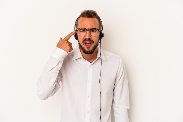 Young caucasian telemarketer man with tattoos isolated on white background  showing a disappointment gesture with forefinger.