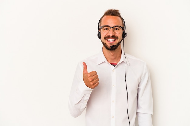 Young caucasian telemarketer man with tattoos isolated on white background  smiling and raising thumb up