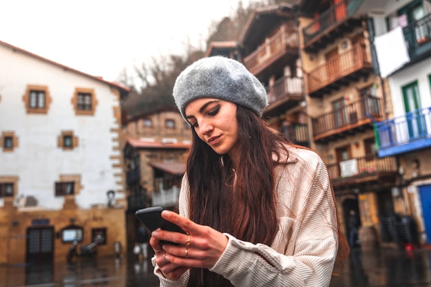 旧市街でスマートフォンを使用して若い白人観光客の女性。