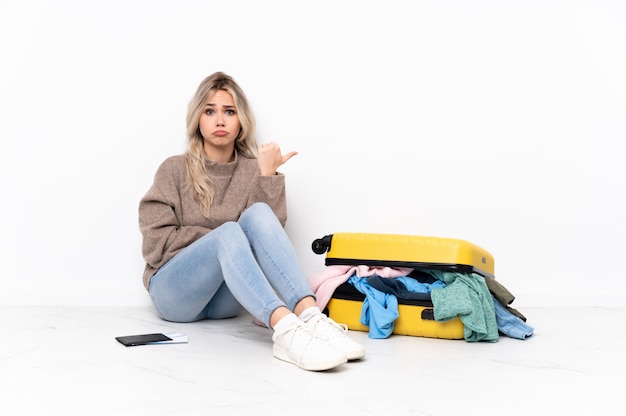 Young caucasian travel woman over sitting on the floor