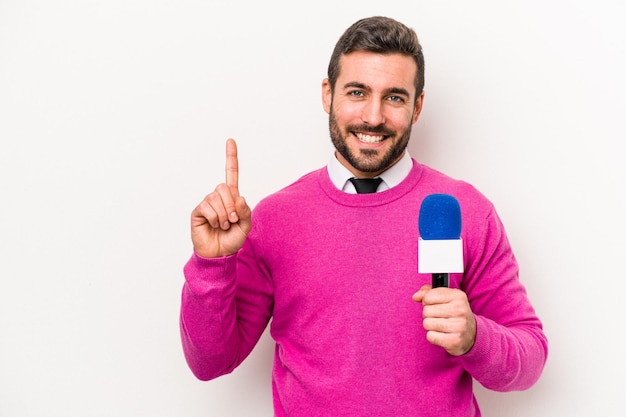 Young caucasian tv presenter man isolated on white background showing number one with finger