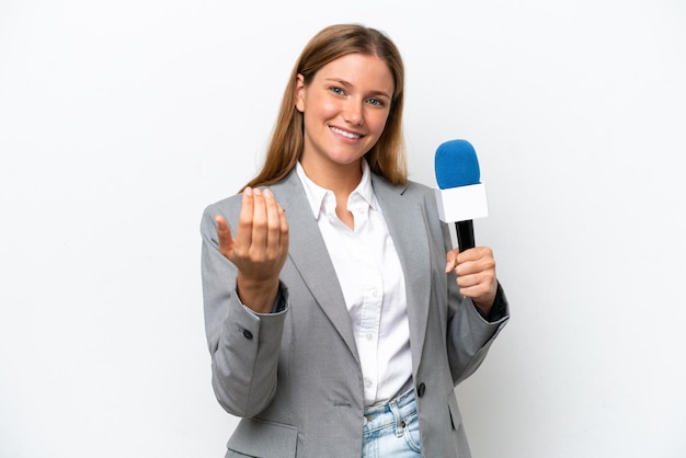 Young caucasian tv presenter woman isolated on white background inviting to come with hand Happy that you came