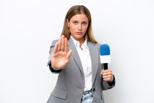 停止ジェスチャーを作る白い背景に分離された若い白人テレビ司会者の女性