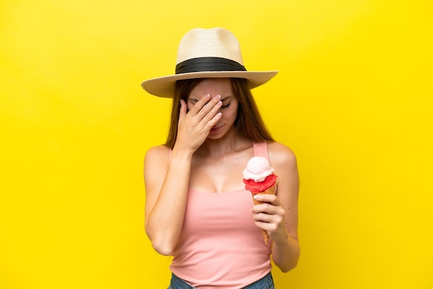 Young caucasian with a cornet ice cream isolated on yellow background with tired and sick expression