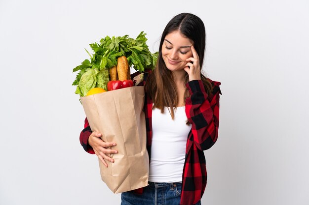 Young caucasian with vegetables isolated on white laughing