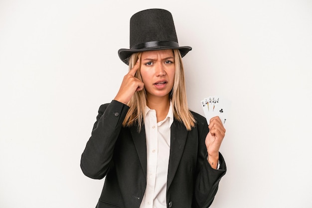 Young caucasian wizard woman holding magic card isolated on white background showing a disappointment gesture with forefinger.