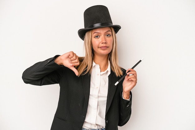 Young caucasian wizard woman holding wand isolated on white background showing a dislike gesture, thumbs down. Disagreement concept.