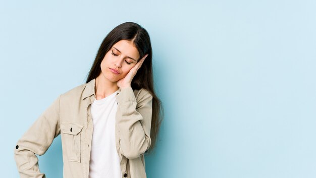 Young caucasian woman on blue wall bored, fatigued and need a relax day.