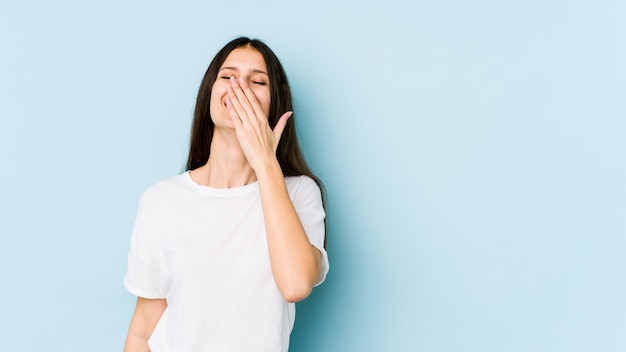 Young caucasian woman on blue wall laughing happy
