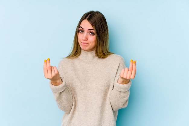 Photo young caucasian woman on blue wall showing that she has no money.