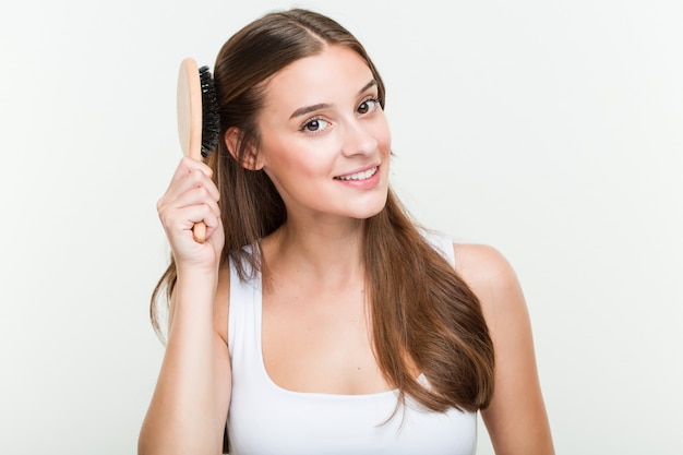 Young caucasian woman brushing her hair