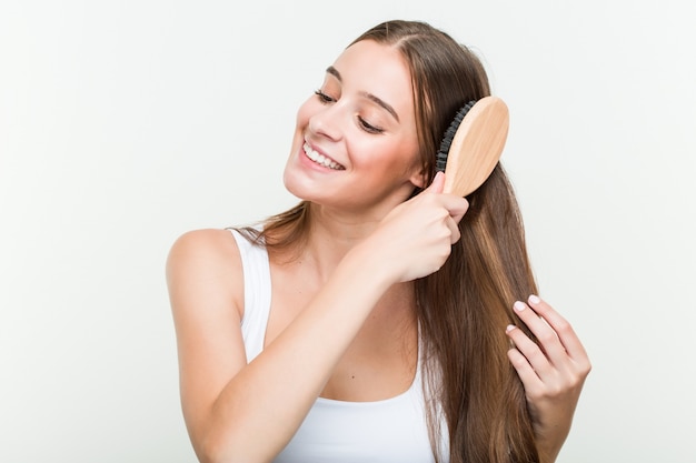 Young caucasian woman brushing her hair