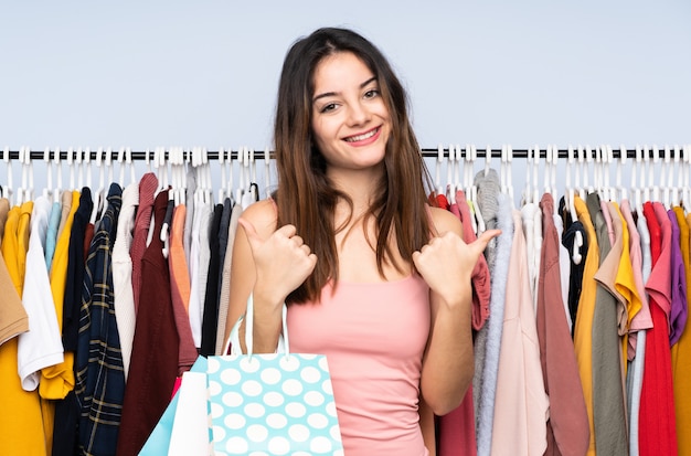 Young caucasian woman buying some clothes in a store with thumbs up gesture and smiling