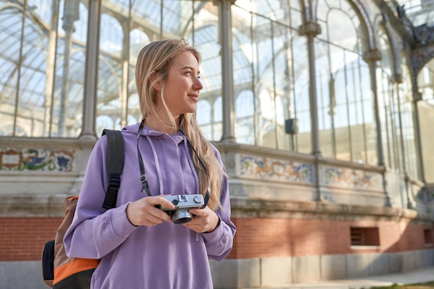 Young caucasian woman captures artistic beauty of the crystal palace in Madrid with her camera