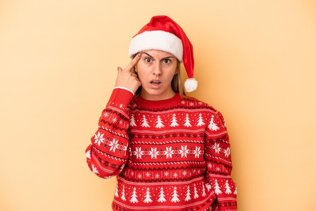 Young caucasian woman celebrating Christmas isolated on yellow background showing a disappointment gesture with forefinger.