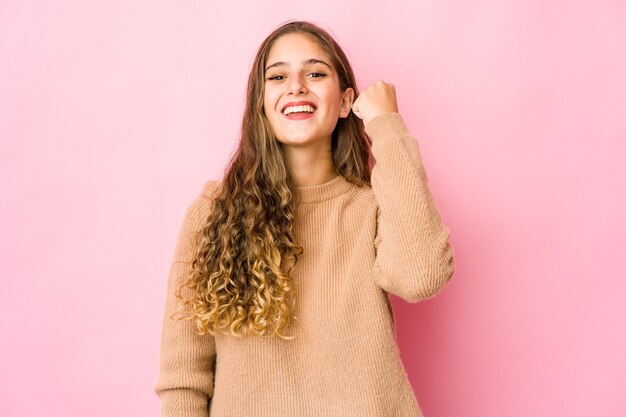 Young caucasian woman celebrating a victory, passion and enthusiasm, happy expression.