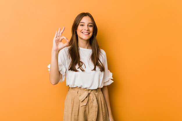 Young caucasian woman cheerful and confident showing ok gesture.