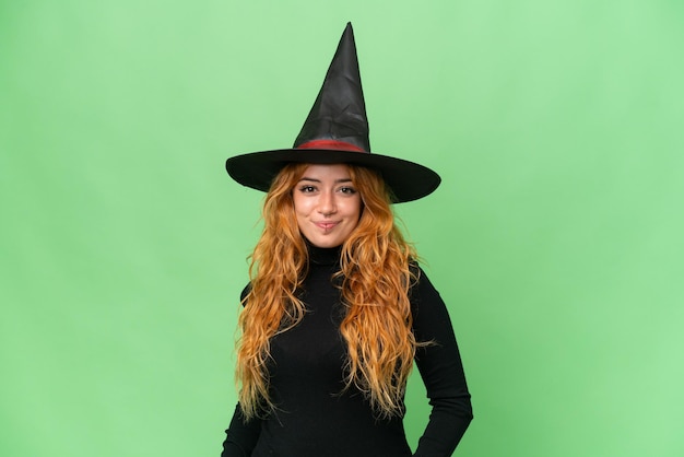 Young caucasian woman costume as witch isolated on green screen chroma key background laughing