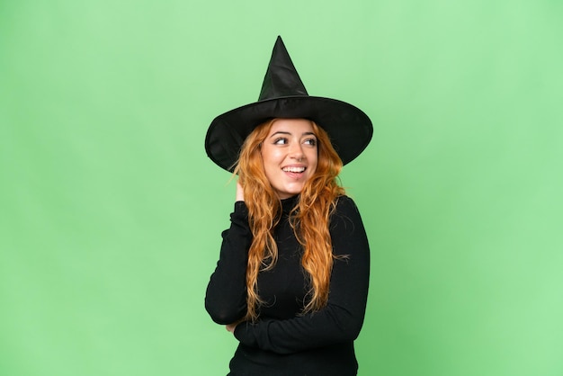 Young caucasian woman costume as witch isolated on green screen chroma key background thinking an idea