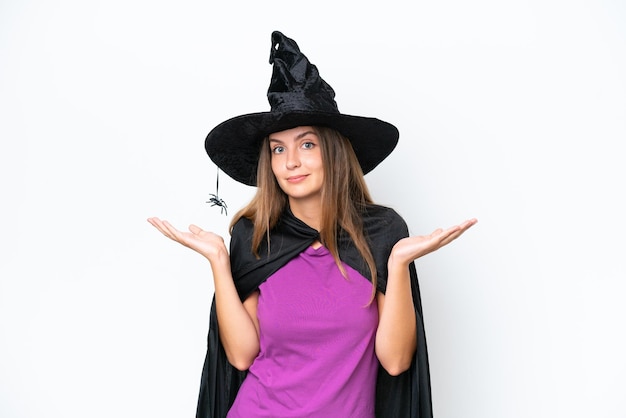 Young caucasian woman costume as witch isolated on white background having doubts while raising hands