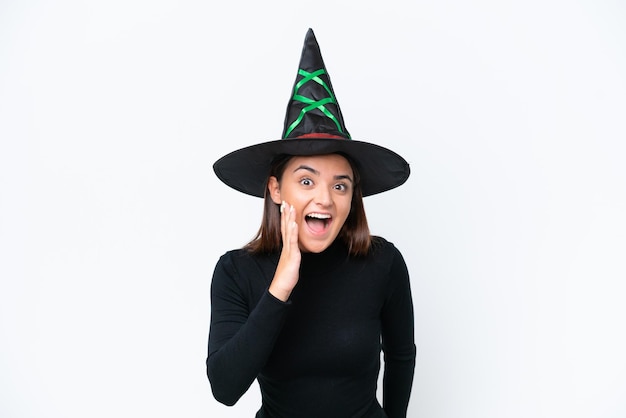 Young caucasian woman costume as witch isolated on white background with surprise and shocked facial expression