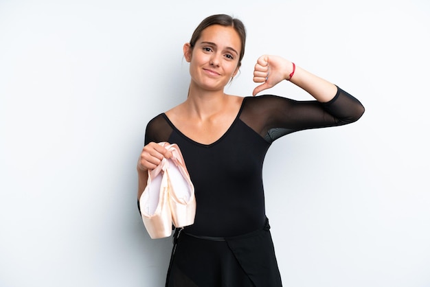 Young caucasian woman dancing ballet isolated on white background showing thumb down with negative expression