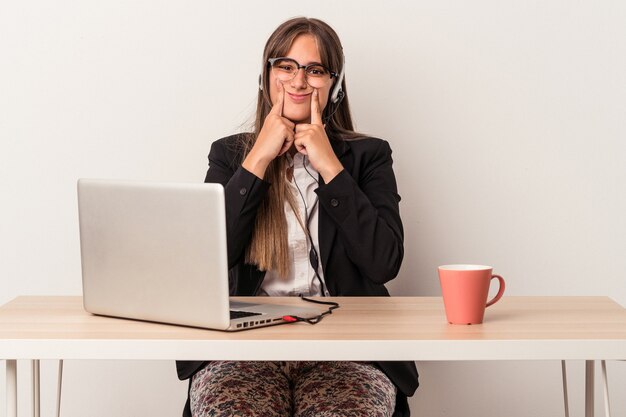 Giovane donna caucasica che fa il telelavoro isolato su sfondo bianco dubitando tra due opzioni.