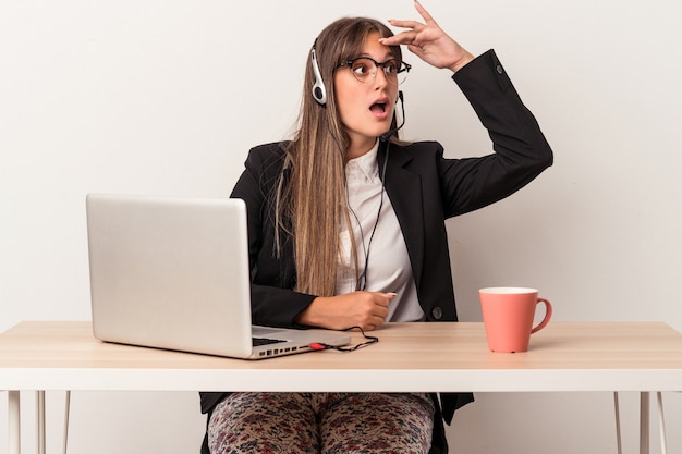 Young caucasian woman doing telecommuting isolated on white background looking far away keeping hand on forehead.