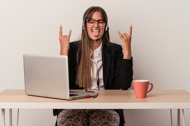 Young caucasian woman doing telecommuting isolated on white background showing rock gesture with fingers