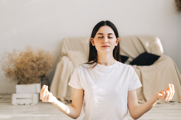 Young caucasian woman doing yoga at home