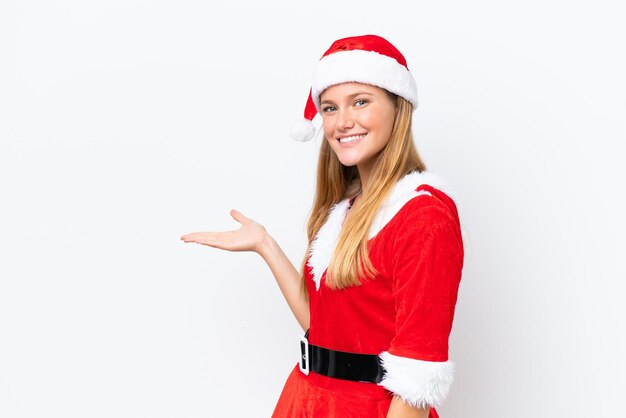 Young caucasian woman dressed as mama noel isolated on white background extending hands to the side for inviting to come