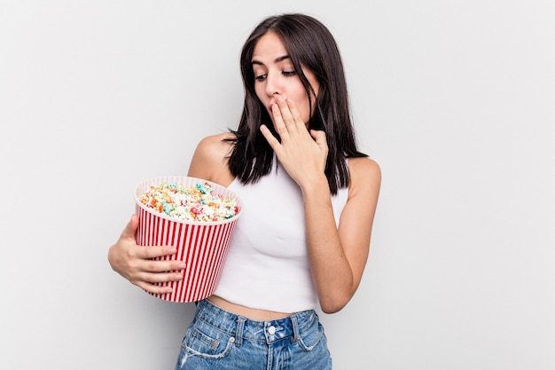 白い背景で隔離ポップコーンを食べる若い白人女性