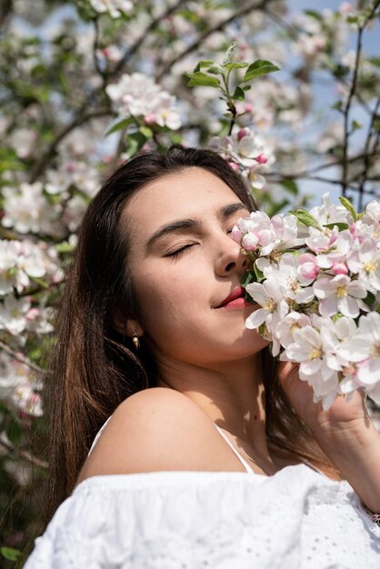 リンゴの木の開花を楽しんでいる若い白人女性