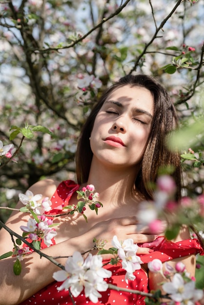 사과 나무의 꽃을 즐기는 젊은 백인 여자
