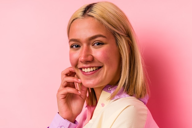 Young caucasian woman face closeup isolated on pink background