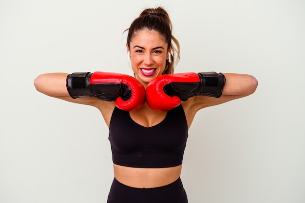 Young caucasian woman fighting with boxing gloves isolated on white wall