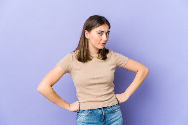 Young caucasian woman frowning face in displeasure, keeps arms folded.