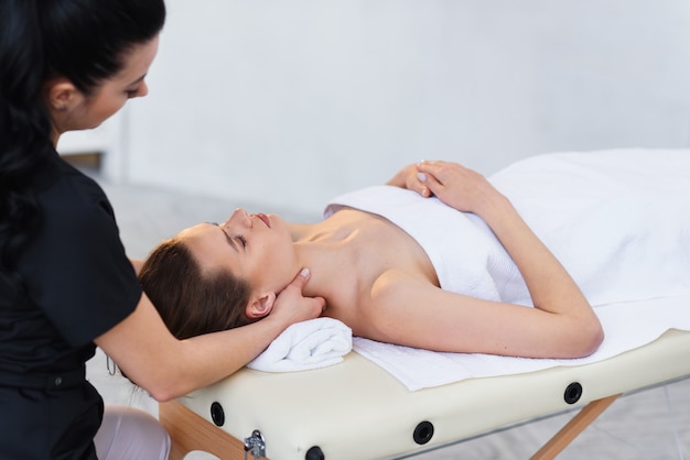 Young caucasian woman getting spa treatment in the modern white salon.