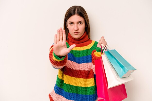 Foto giovane donna caucasica che va a fare shopping isolato su sfondo bianco in piedi con la mano tesa che mostra il segnale di stop che ti impedisce