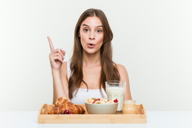 Young caucasian woman having breakfast having some great idea, concept of creativity.