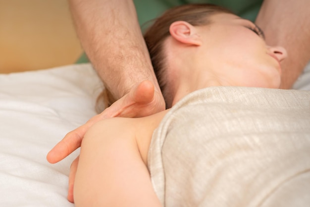 Young caucasian woman having a massage on the shoulder in spa salon.